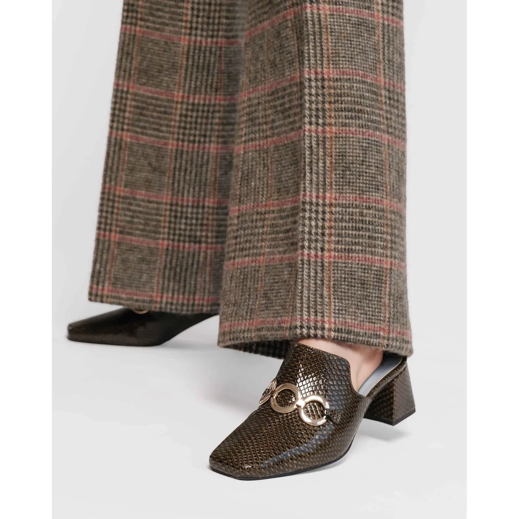 Brown checkered pants with a patterned shoe on a light gray background