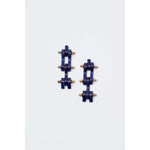 The Rachel Comey Bedford Earrings in Lapis feature a geometric design with navy blue blocks and small gold spheres arranged in an alternating pattern. Crafted with surgical steel backs, these stylish pieces exemplify exceptional craftsmanship and elegance, embodying the renowned artistry of being made in Italy.