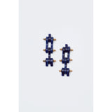 The Rachel Comey Bedford Earrings in Lapis feature a geometric design with navy blue blocks and small gold spheres arranged in an alternating pattern. Crafted with surgical steel backs, these stylish pieces exemplify exceptional craftsmanship and elegance, embodying the renowned artistry of being made in Italy.