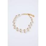 The Rachel Comey Bedford Choker is a gold-tone bracelet featuring a delicate chain design with interlocking links and evenly spaced bead accents. It includes an adjustable lobster clasp with extra chain links and is presented against a white background.