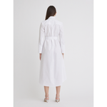 A woman with straight brown hair is standing and facing away from the camera. She is wearing a Matthew Bruch Cargo Button Up Midi White Poplin Shirt Dress, a 100% cotton, long-sleeved, belted design crafted in the USA. Complementing her outfit are white heeled sandals, all set against a plain white background. This elegant piece should be dry cleaned only.