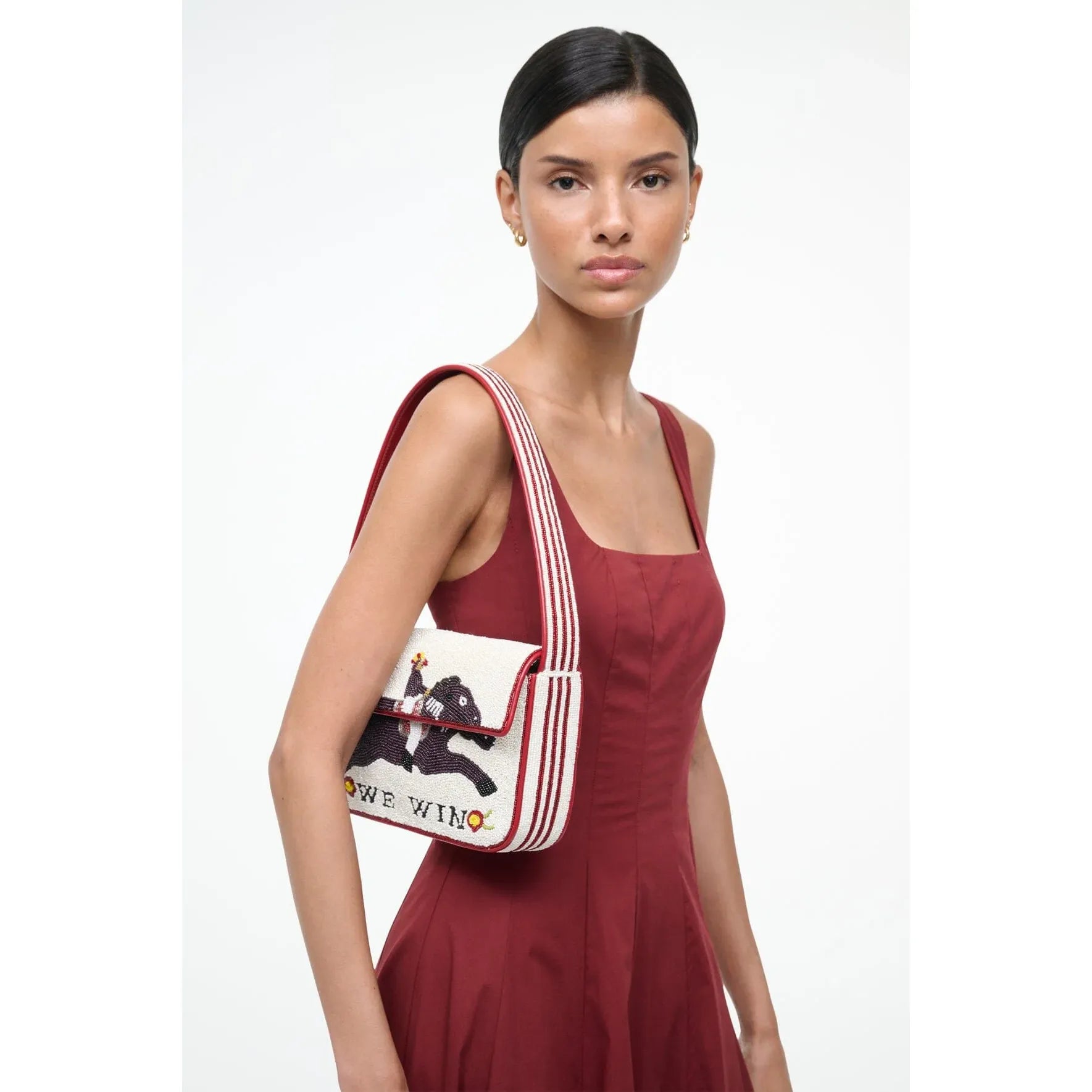 Woman wearing a red dress with a white bag featuring a bear design on a white background