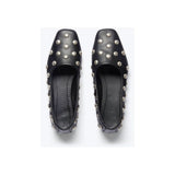 A pair of Freda Salvador's Jessie Ballet Flats, handcrafted in black, featuring a square toe and embellished with silver studs on the top and sides, set against a light gray background.